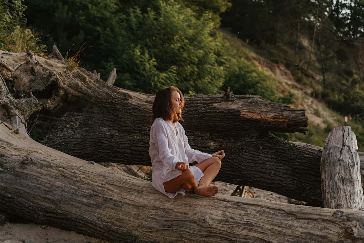 Person practicing somatic therapy mindfulness outdoors, using breath and body awareness to regulate the nervous system.
