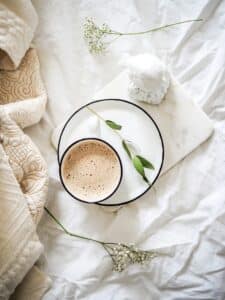 Cup of tea placed on white fabric, simple scene conveying warmth, rest, and quiet presence