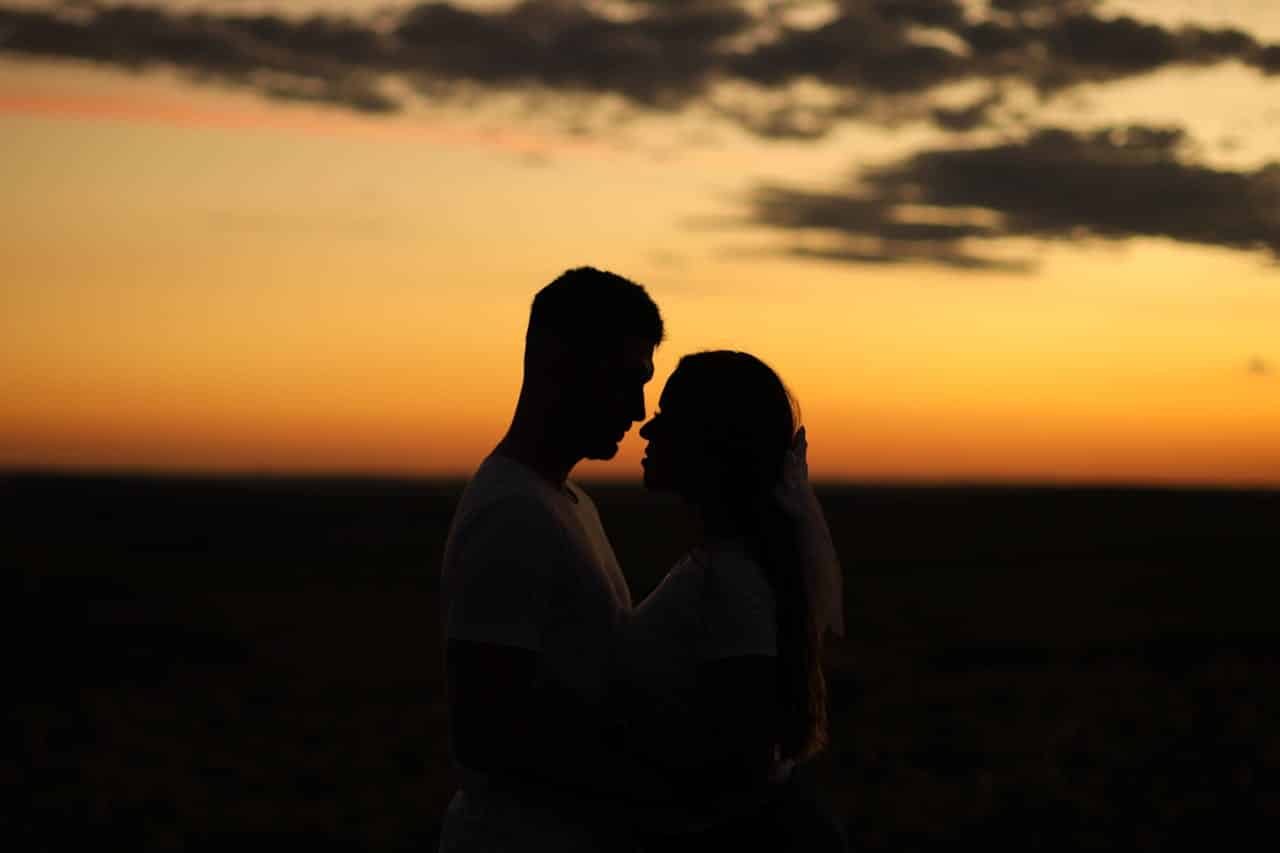 Couple standing closely together at sunset reflecting emotional connection and relationship support